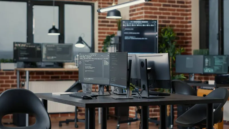 Modern office with workstations running code